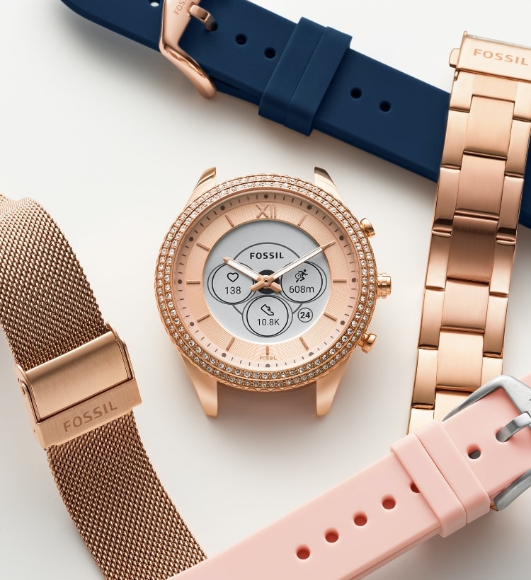 A Gen 6 Hybrid smartwatch dial and different interchangeable straps, including navy silicone, blush silicone, blush mesh, and gold-tone stainless steel bracelet.