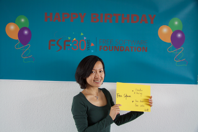Image of someone in front of a Happy Birthday FSF30 banner