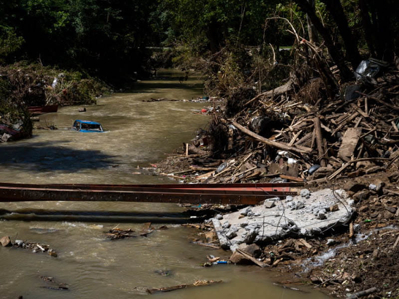 A partially submerged car in a creek near Hazard, Kentucky after the historic flooding in the summer of 2022. (Michael Swensen/Stringer via Getty Images North America)