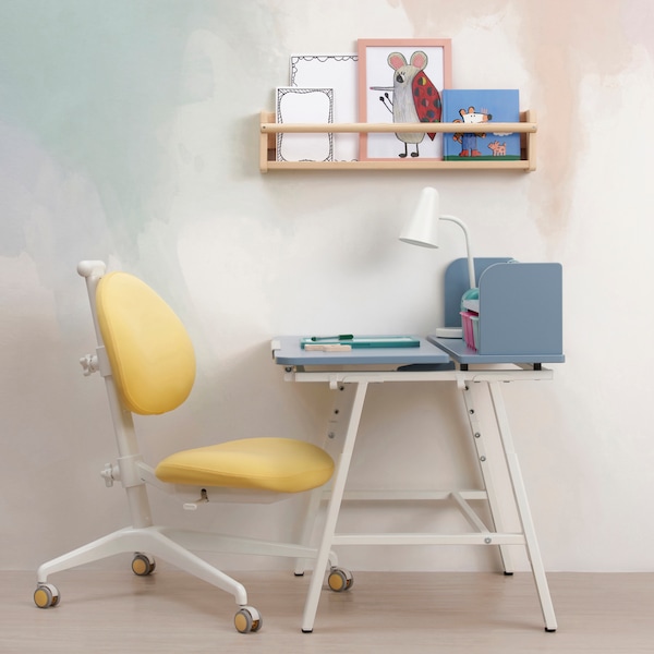 PIPLARKA blue children desk with a yellow GUNRIK children's desk chair under a FLISAT book shelf mounted on the wall. 