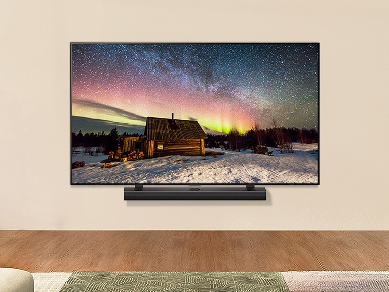 Un LG TV et une barre de son LG dans un salon moderne pendant la journée. L’écran affiche une image de l’aurore boréale avec une luminosité idéale.
