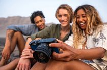 Three young people looking at the back of a camera and smiling more than neccessary