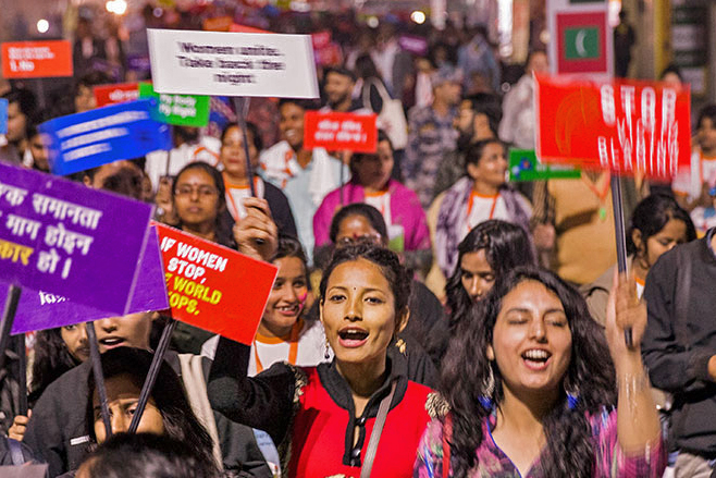 A large group of women marching while holding signs.