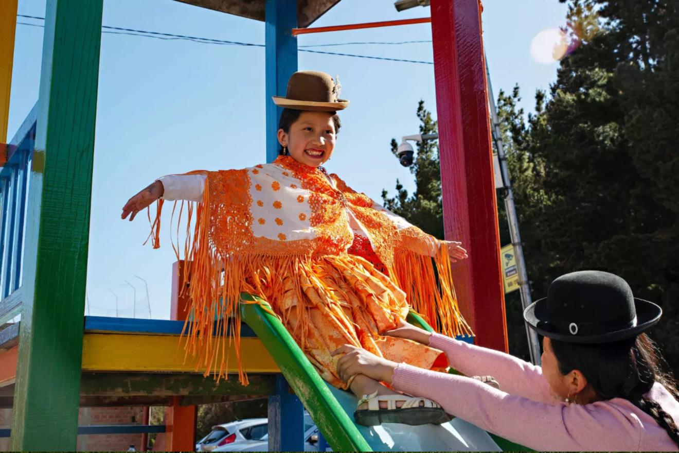 A woman helps her daughter down a slide at a playground in La Paz, Bolivia.