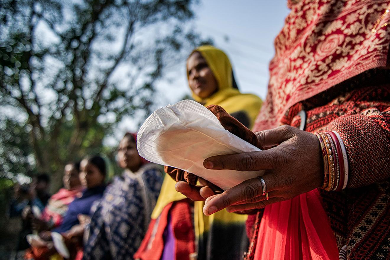 En el estado de Sitamarhi, Bihar, la India, en 2022, varias mujeres sujetan compresas durante una campaña informativa como parte del programa de gestión de la higiene menstrual organizado por UNICEF. 
