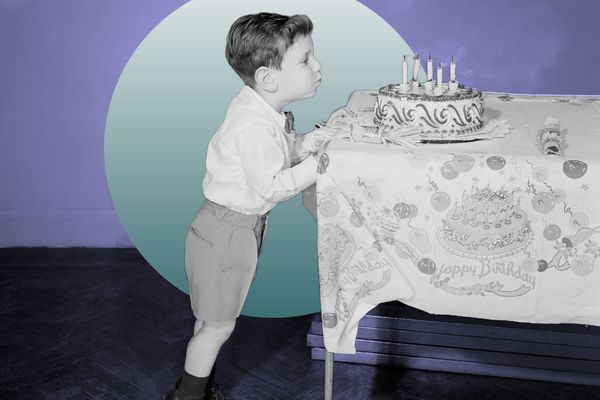 Little boy blowing out candles on birthday cake